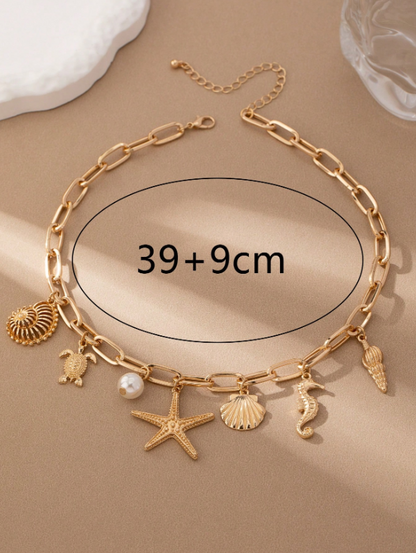 Gold chain bracelet with charms on a beige background