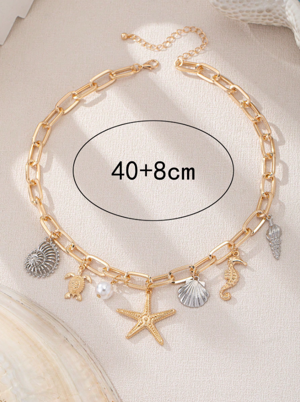 Gold chain anklet with charms on a beige background