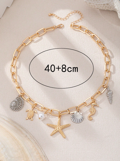 Gold chain anklet with charms on a beige background