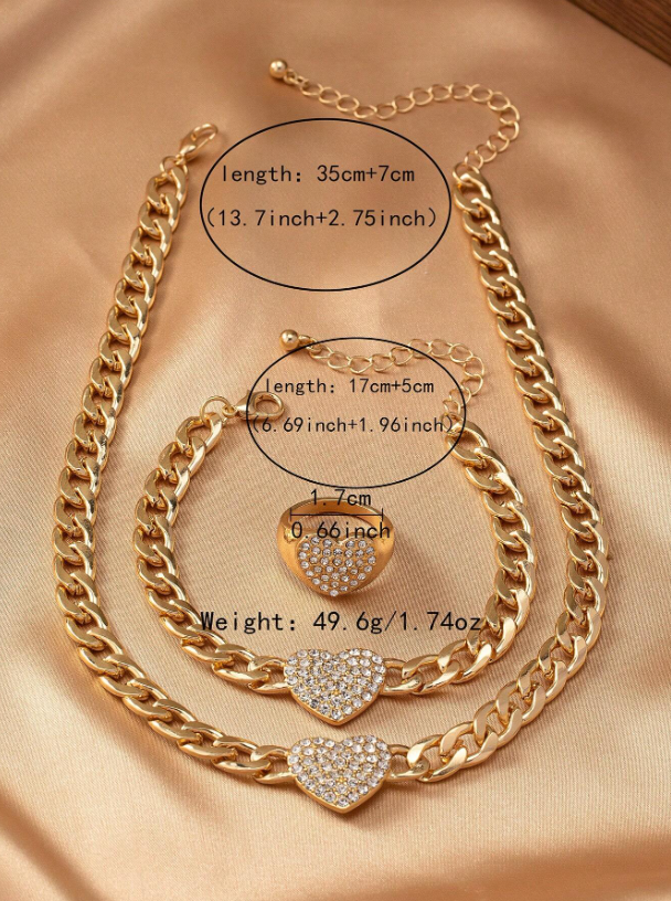 Gold chain necklace with heart-shaped pendants on a beige fabric background