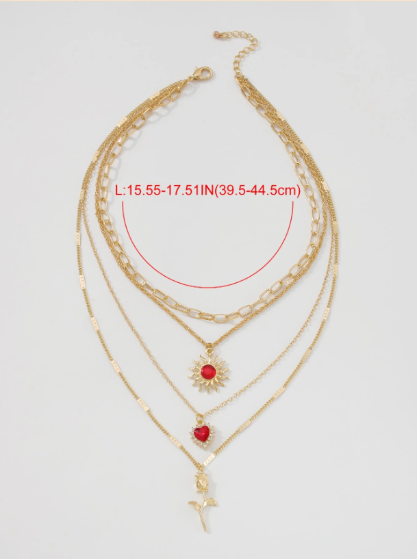 Gold necklace with red heart and sunflower pendants on a light gray background
