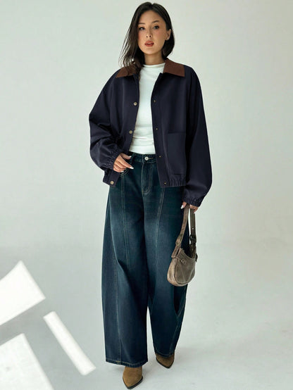 A woman wearing a Royal Blue casual jacket with a contrasting brown lapel collar, drop shoulders, and front pockets paired with a white tee and dark jeans