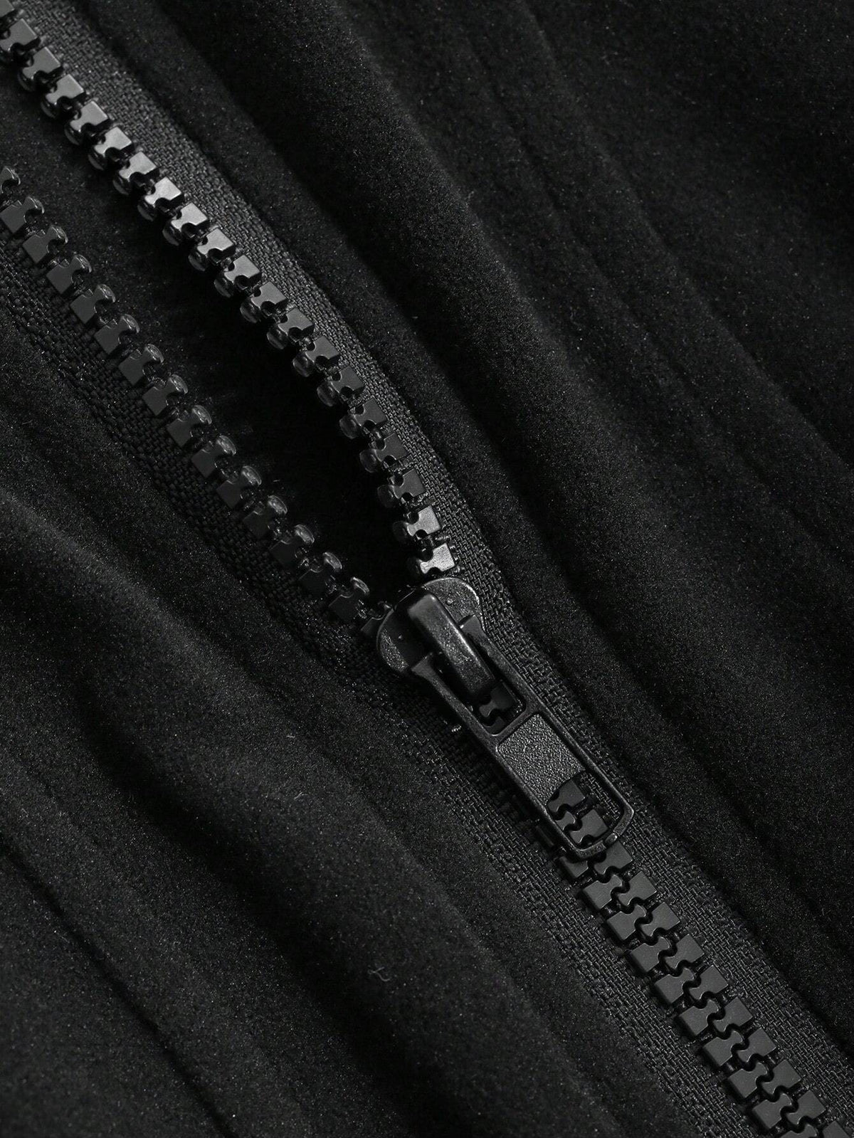 A woman wearing a black ribbed trim zip-up sweatshirt jacket with a high mock neck paired with light grey sweatpants