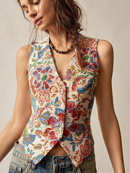 A woman wearing a multicolor floral jacquard boho vest with a V-neck and button closure paired with denim jeans
