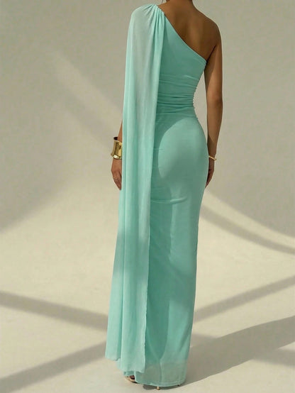 A woman wearing an elegant Mint Dress one-shoulder ruched mermaid long dress with a dramatic flutter cloak sleeve