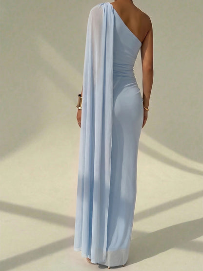 A woman wearing an elegant light blue one-shoulder ruched mermaid long dress with a dramatic flutter cloak sleeve