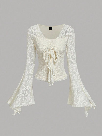 Apricot sheer floral lace tie-front long flare sleeve top laid flat against a neutral background