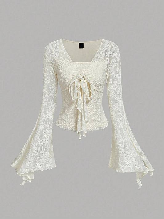 Apricot sheer floral lace tie-front long flare sleeve top laid flat against a neutral background