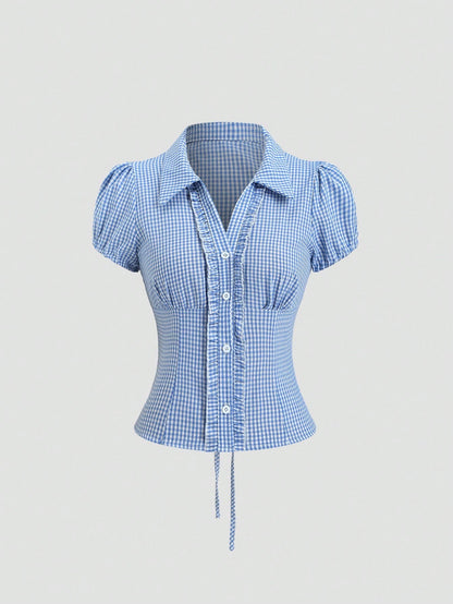 Blue and white gingham plaid short-sleeve polo collar peplum blouse with front ruffles and a laced-up back detail laid flat