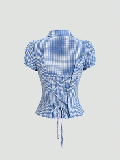 Blue and white gingham plaid short-sleeve polo collar peplum blouse with front ruffles and a laced-up back detail laid flat