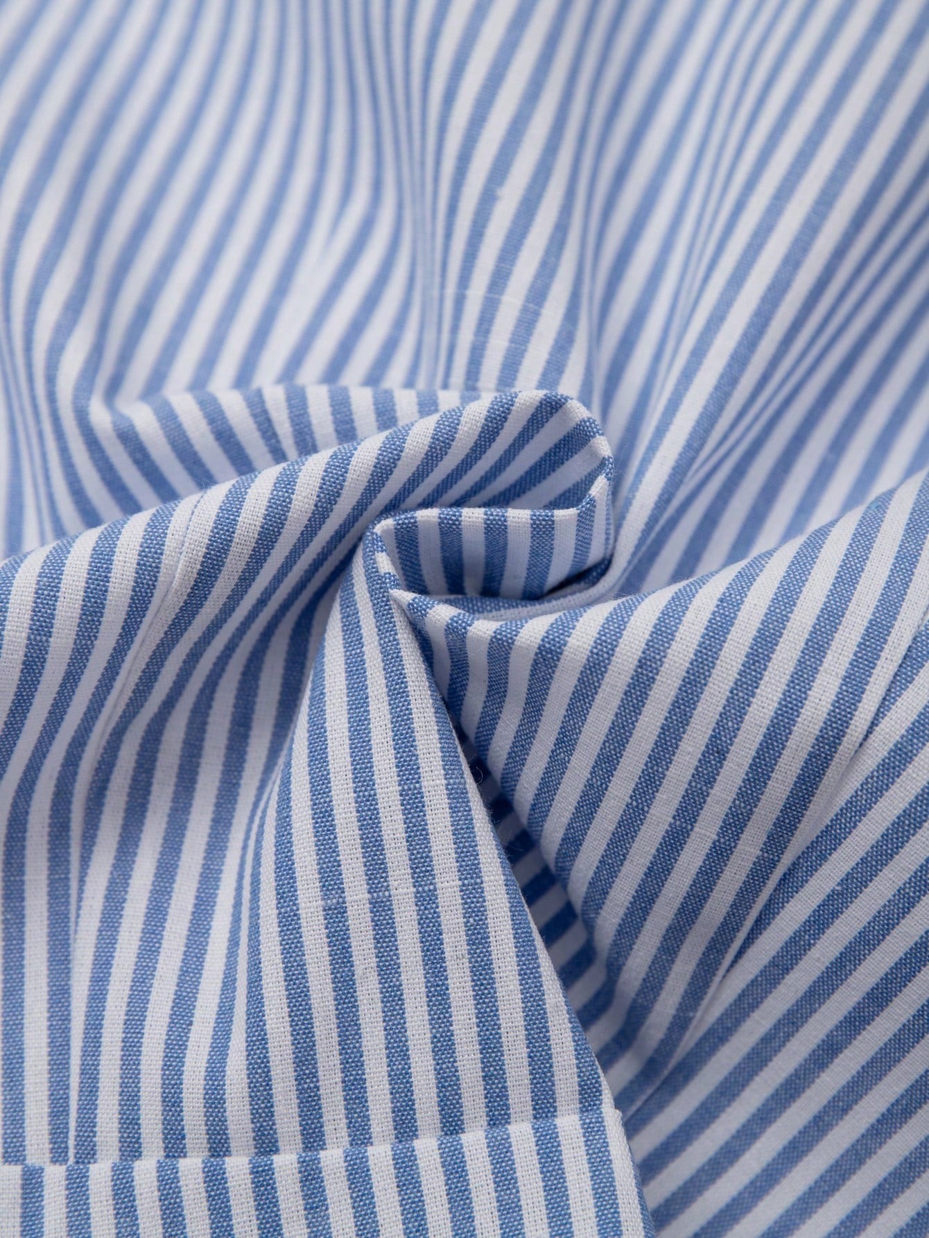 Blue and white striped 2-in-1 cropped blouse with a lapel collar and built-in white V-neck insert laid flat