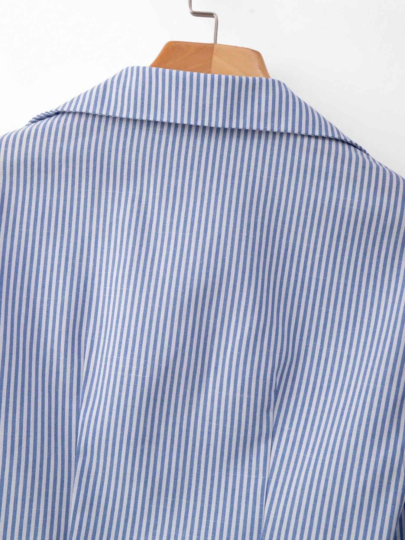 Blue and white striped 2-in-1 cropped blouse with a lapel collar and built-in white V-neck insert laid flat