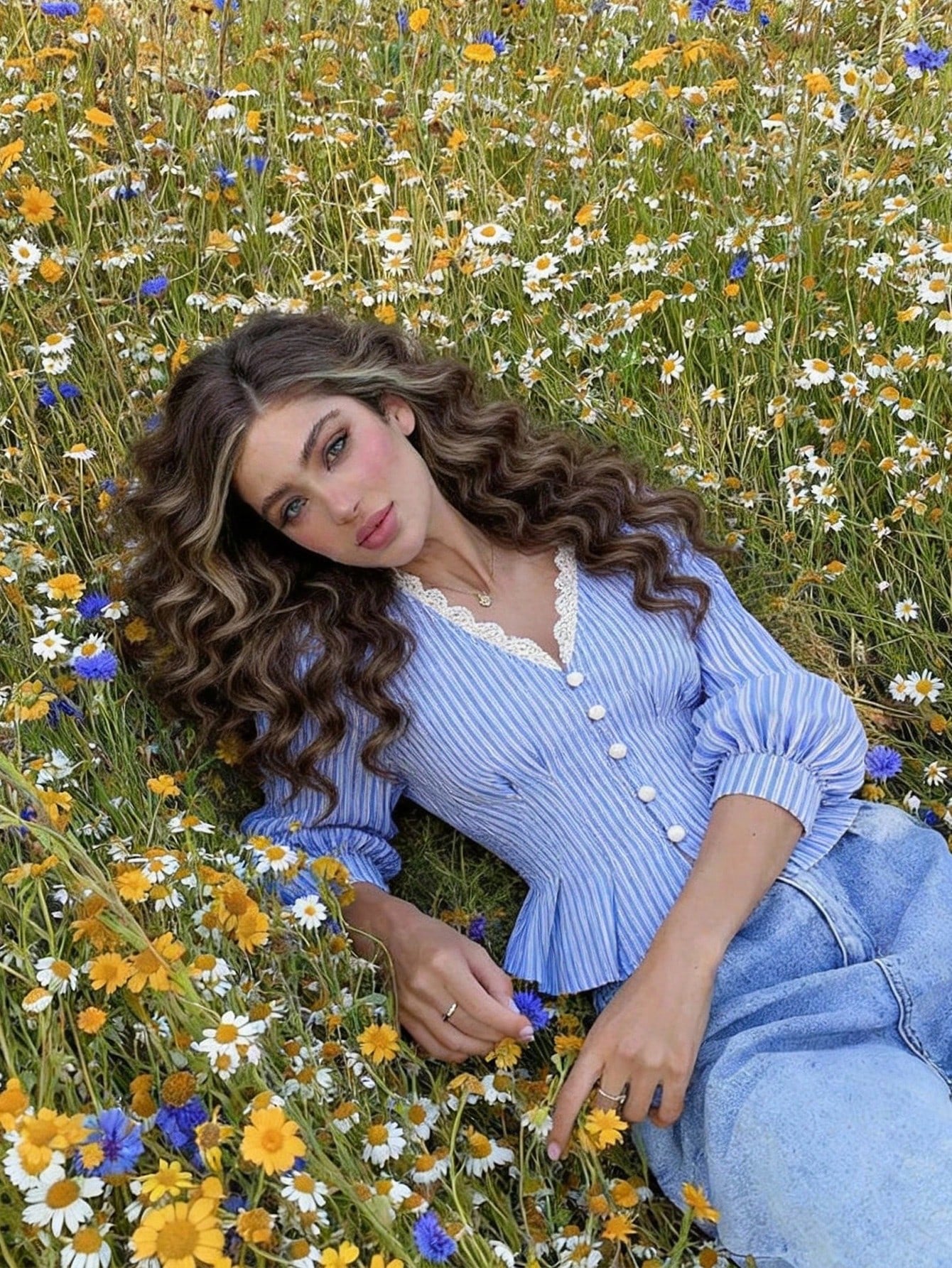 Blue and white striped long-sleeve peplum blouse with a lace-trim V-neck, button-front closure, and lantern sleeves against a neutral background.