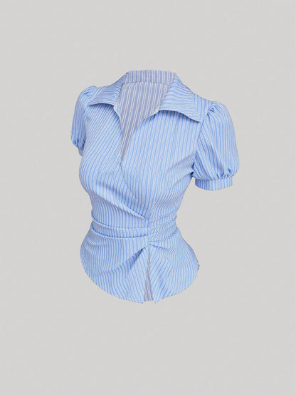 Blue and white striped short-sleeve polo collar peplum blouse with a wrap-effect ruched waist laid flat against a neutral background