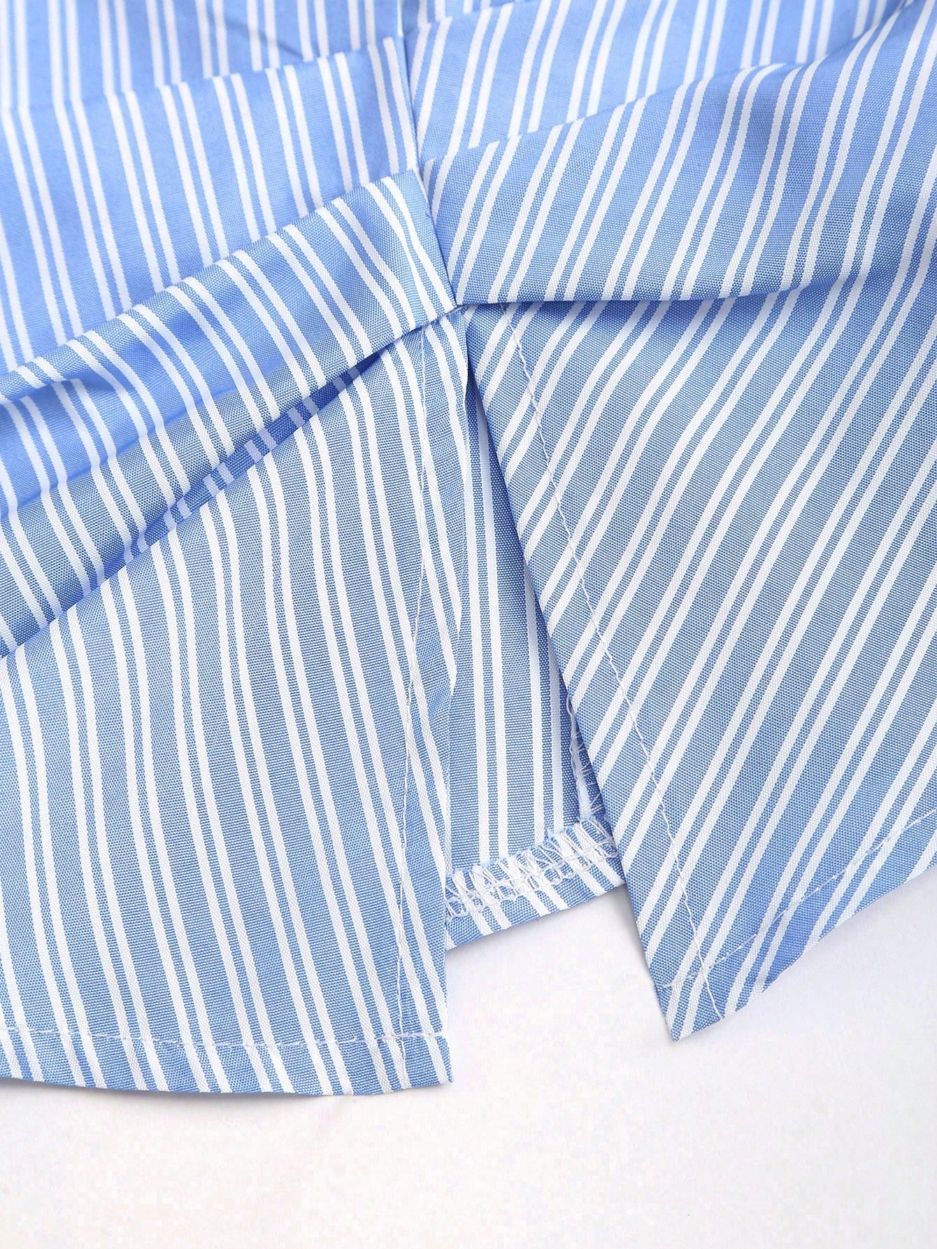 Blue and white striped short-sleeve polo collar peplum blouse with a wrap-effect ruched waist laid flat against a neutral background