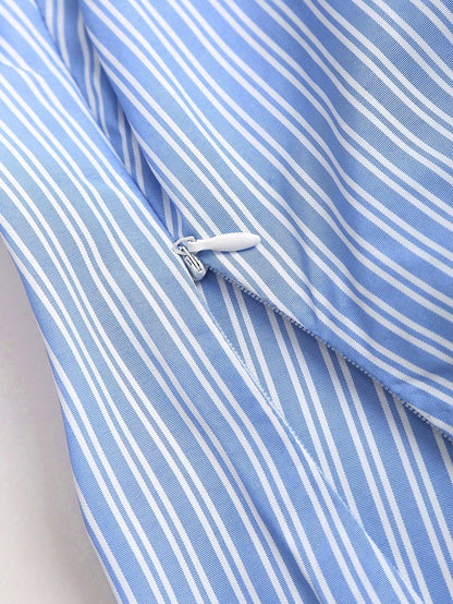 Blue and white striped short-sleeve polo collar peplum blouse with a wrap-effect ruched waist laid flat against a neutral background