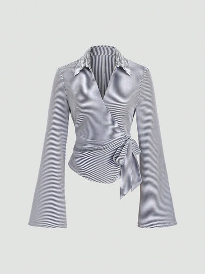 Blue and white striped wrap blouse with a collar, waist bow tie, and long flare sleeves laid flat against a neutral background