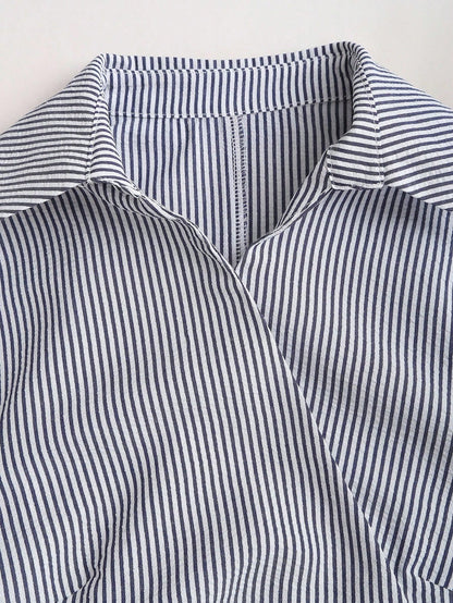 Blue and white striped wrap blouse with a collar, waist bow tie, and long flare sleeves laid flat against a neutral background