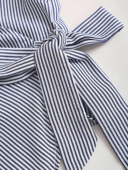 Blue and white striped wrap blouse with a collar, waist bow tie, and long flare sleeves laid flat against a neutral background