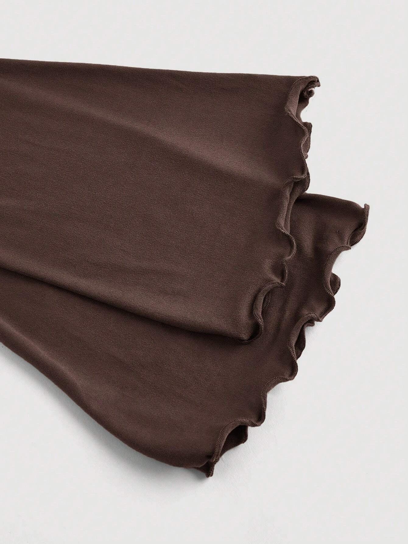 Brown asymmetric neckline ruched long flare sleeve top laid flat against a neutral background