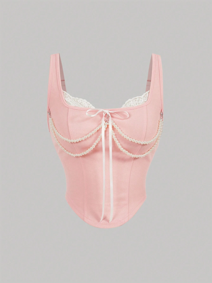 Pink lace lingerie with pearl details on a gray background