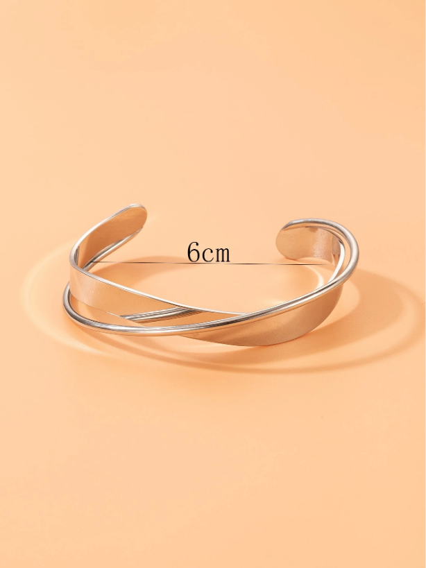 Silver bangle on a peach background with measurement text