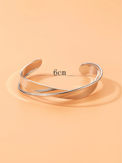 Silver bangle on a peach background with measurement text