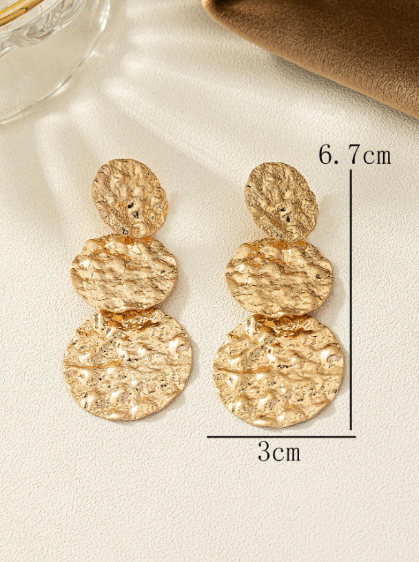 Gold earrings on a light background with measurement details.