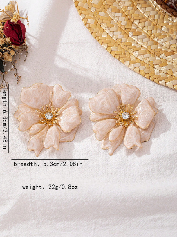 Pair of floral earrings with gold accents on a white surface.