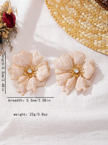 Pair of floral earrings with gold accents on a white surface.