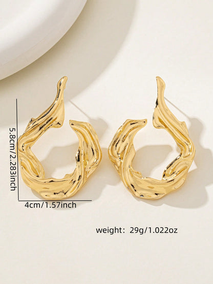 Gold earrings with measurements and weight on a light background