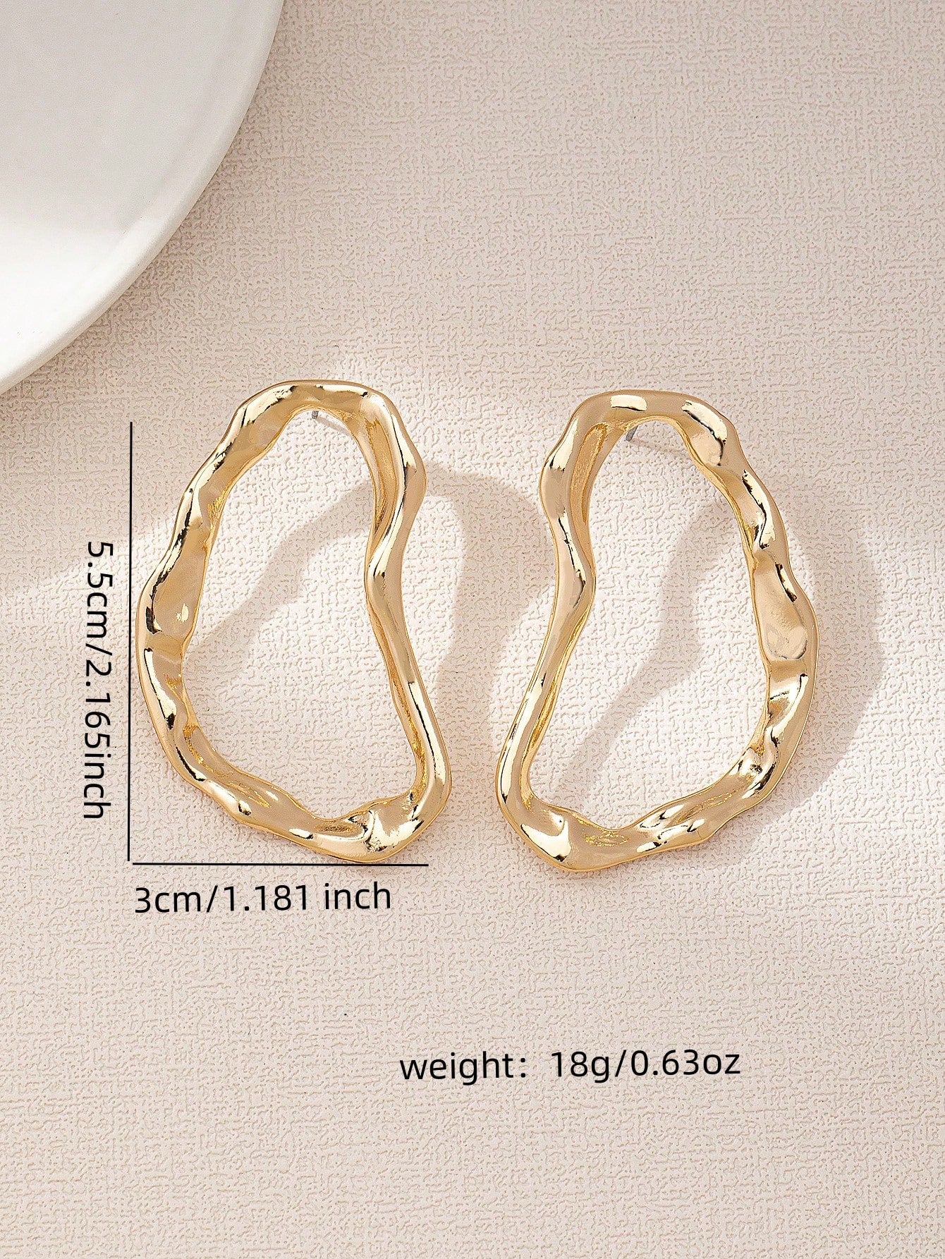 Gold hoop earrings on a beige background with measurements and weight displayed.