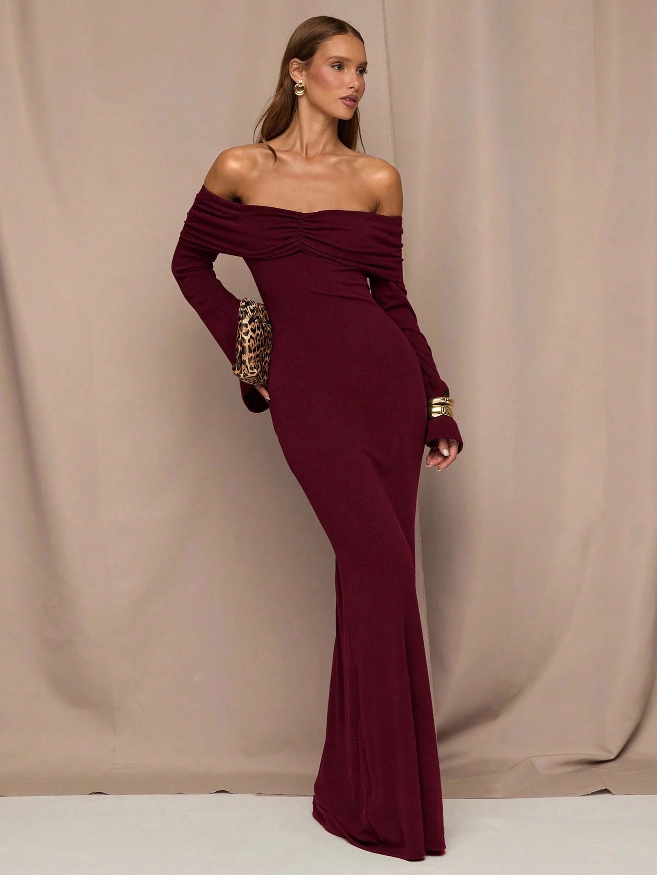 Fashzeo maroon off-shoulder long sleeve gown with ruched neckline.