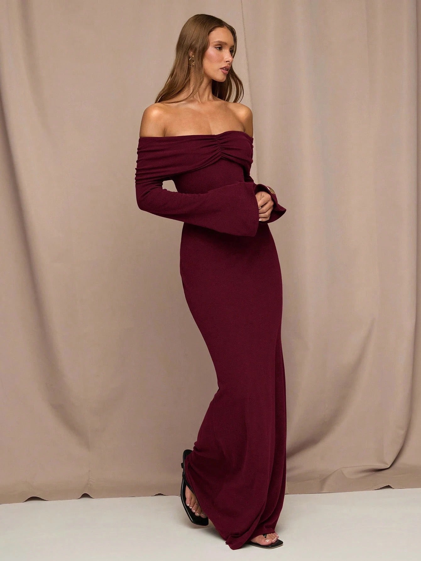 Fashzeo maroon off-shoulder long sleeve gown with ruched neckline.