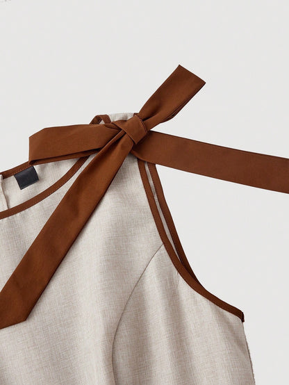 Khaki wide-leg sleeveless jumpsuit featuring contrast brown shoulder bow ties and trim laid flat against a neutral background