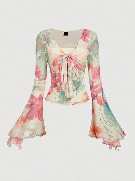 Pink and green floral print long-sleeve flare blouse with a V-neck and twist-front tie detail laid flat against a neutral background