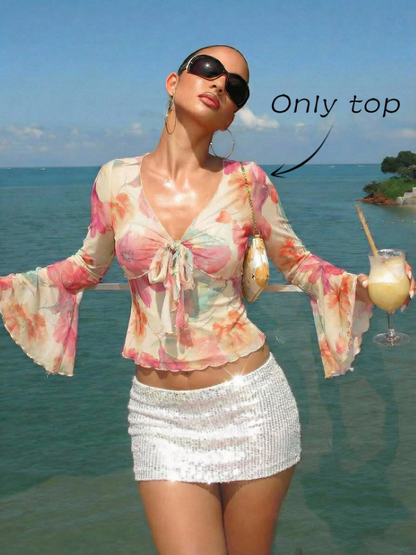 Pink and green floral print long-sleeve flare blouse with a V-neck and twist-front tie detail laid flat against a neutral background