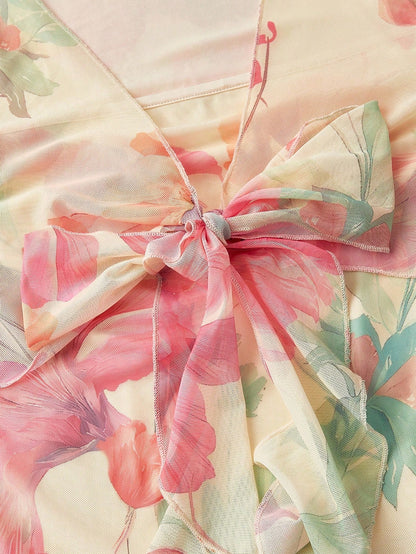 Pink and green floral print long-sleeve flare blouse with a V-neck and twist-front tie detail laid flat against a neutral background