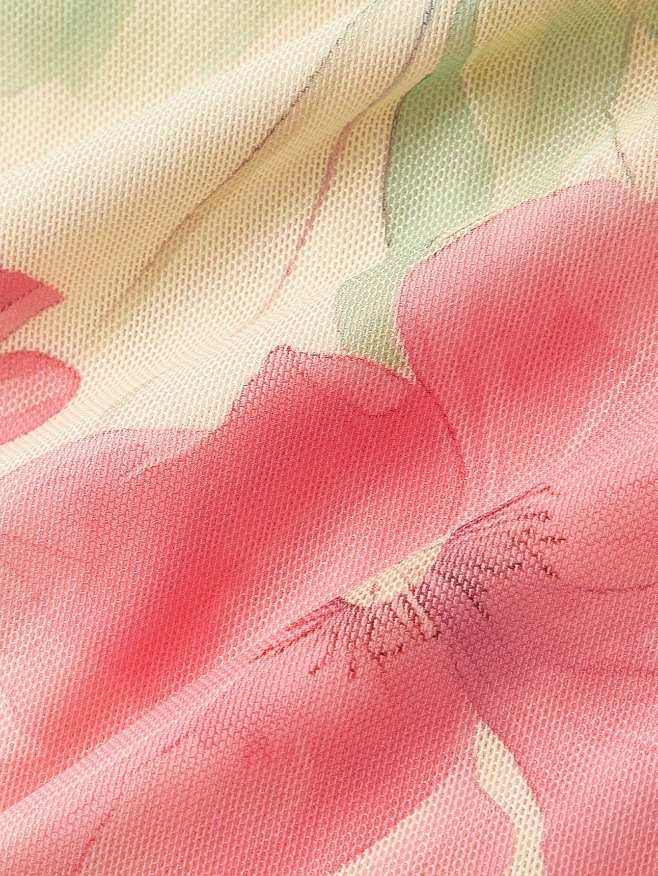 Pink and green floral print long-sleeve flare blouse with a V-neck and twist-front tie detail laid flat against a neutral background