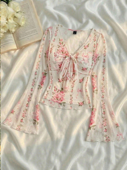 Pink and white floral print tie-front flare sleeve top laid flat against a neutral background