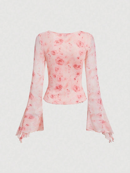 Pink floral print sheer mesh long-sleeve top with a tie-front closure, V-neck, and dramatic bell sleeves on a neutral background.