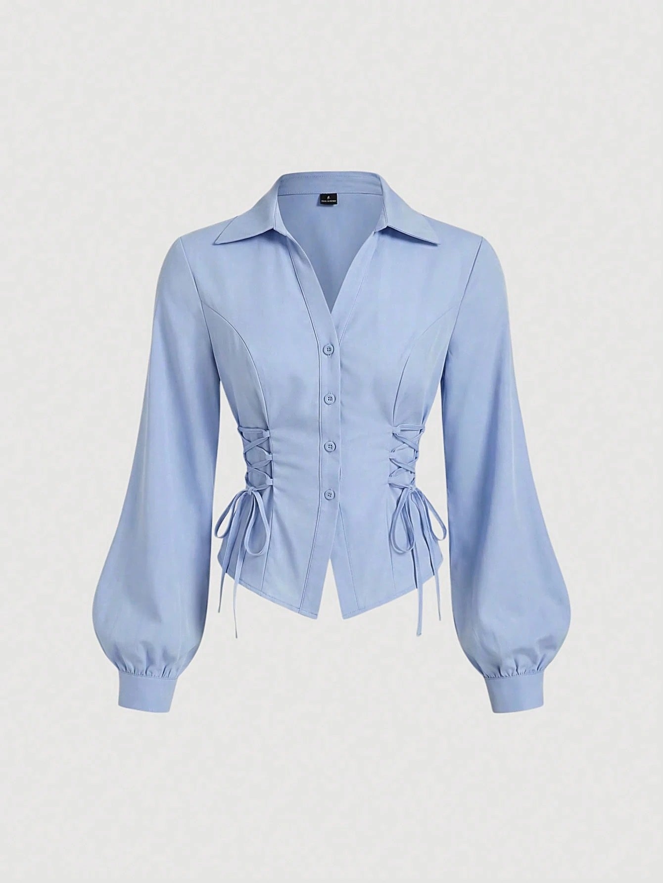 Solid color blue button-down shirt with lapel collar, lantern sleeves, and waist lace-up corset ties laid flat