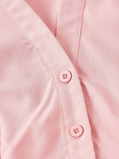 Solid color pink button-down shirt with lapel collar, lantern sleeves, and waist lace-up corset ties laid flat
