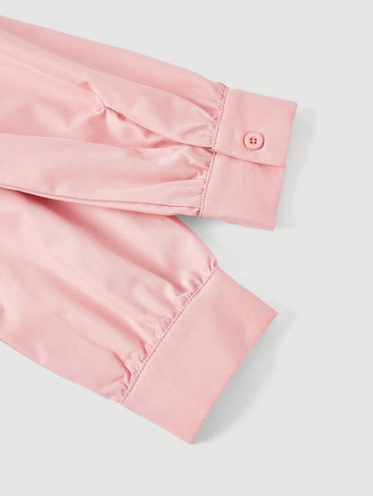 Solid color pink button-down shirt with lapel collar, lantern sleeves, and waist lace-up corset ties laid flat