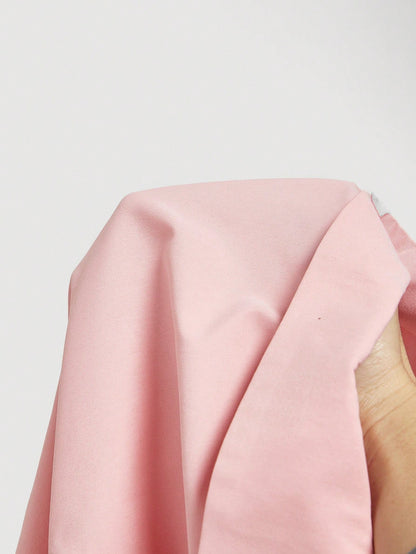Solid color pink button-down shirt with lapel collar, lantern sleeves, and waist lace-up corset ties laid flat