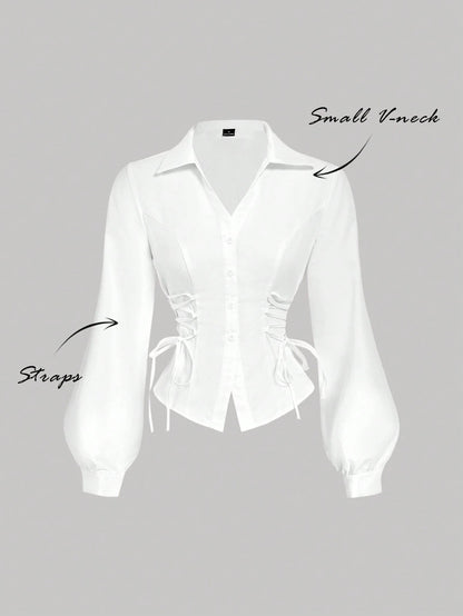 Solid color white button-down shirt with lapel collar, lantern sleeves, and waist lace-up corset ties laid flat