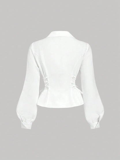 Solid color white button-down shirt with lapel collar, lantern sleeves, and waist lace-up corset ties laid flat
