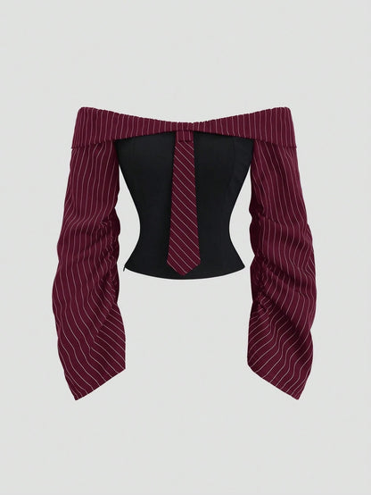 Two-tone off-shoulder black top with striped maroon sleeves and an attached necktie detail laid flat against a neutral background