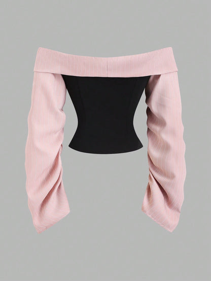 Two-tone off-shoulder black top with striped pink sleeves and an attached necktie detail laid flat against a neutral background