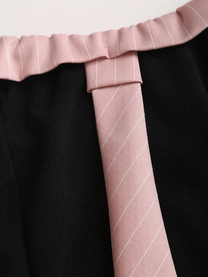 Two-tone off-shoulder black top with striped pink sleeves and an attached necktie detail laid flat against a neutral background